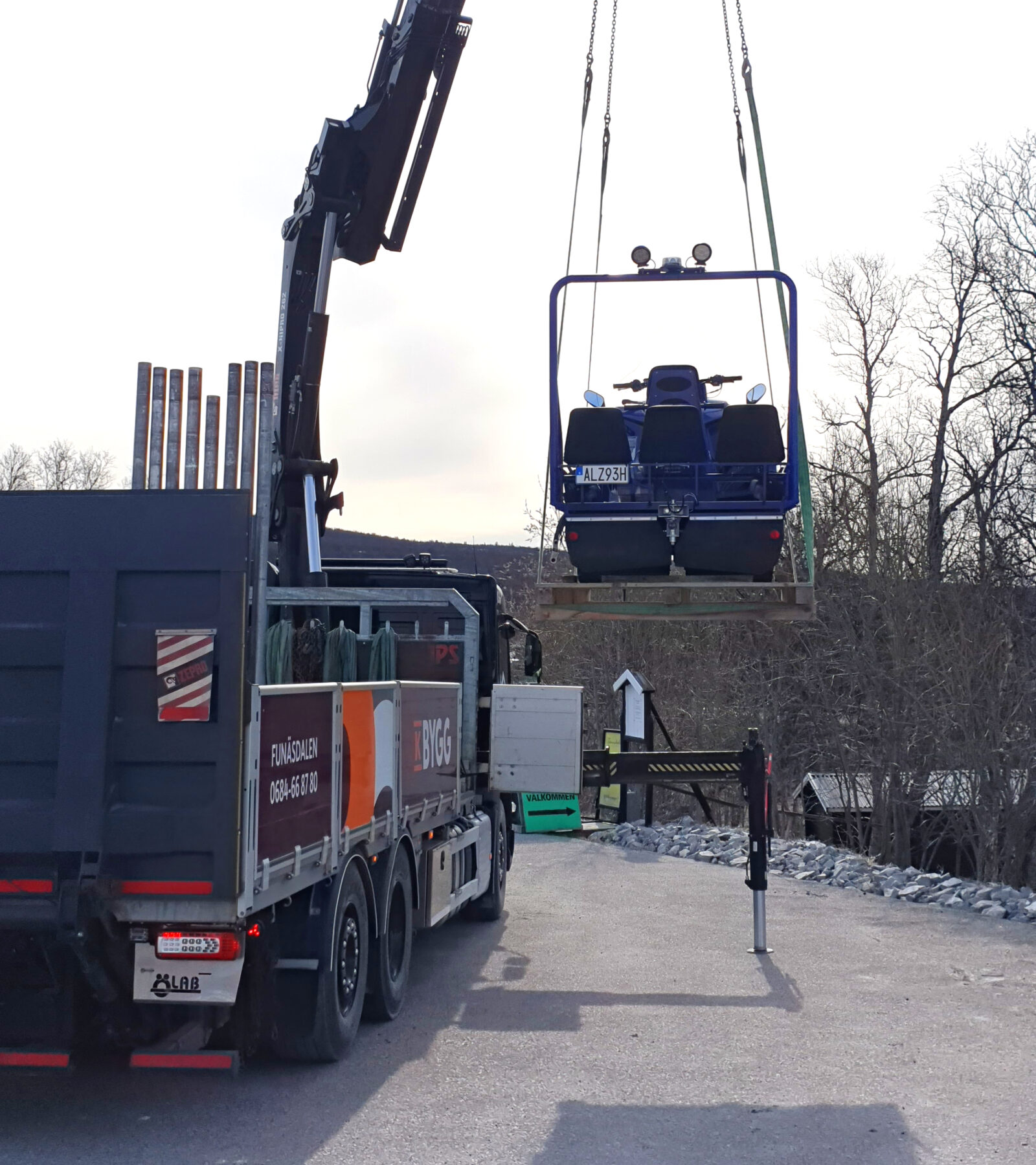 Alpina Sherpa 2017 dual-track snowmobile being lifted by a crane for transport to Stockholm.